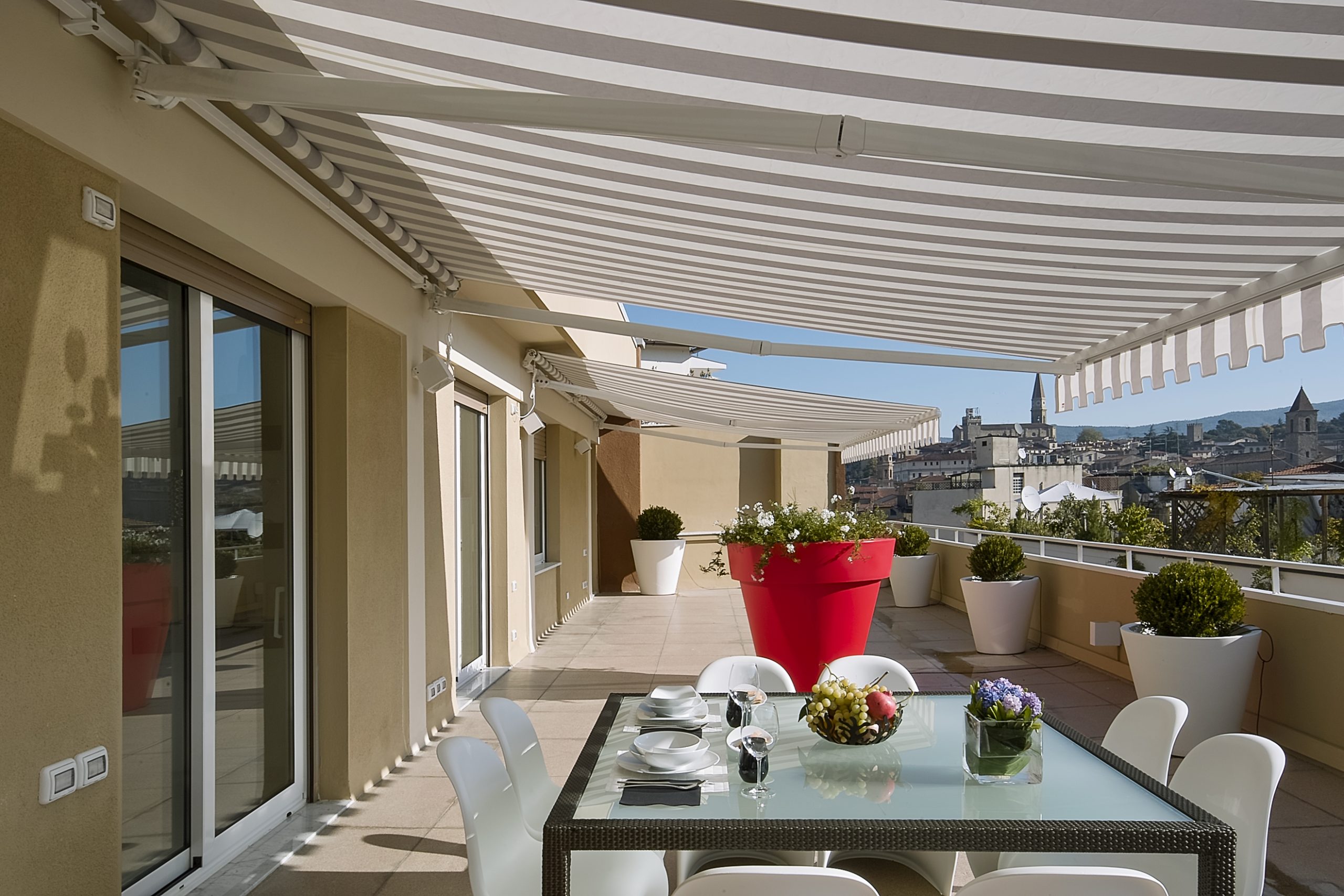 Retractable awning providing shade, a perfect outdoor window treatment for an outdoor seating area.